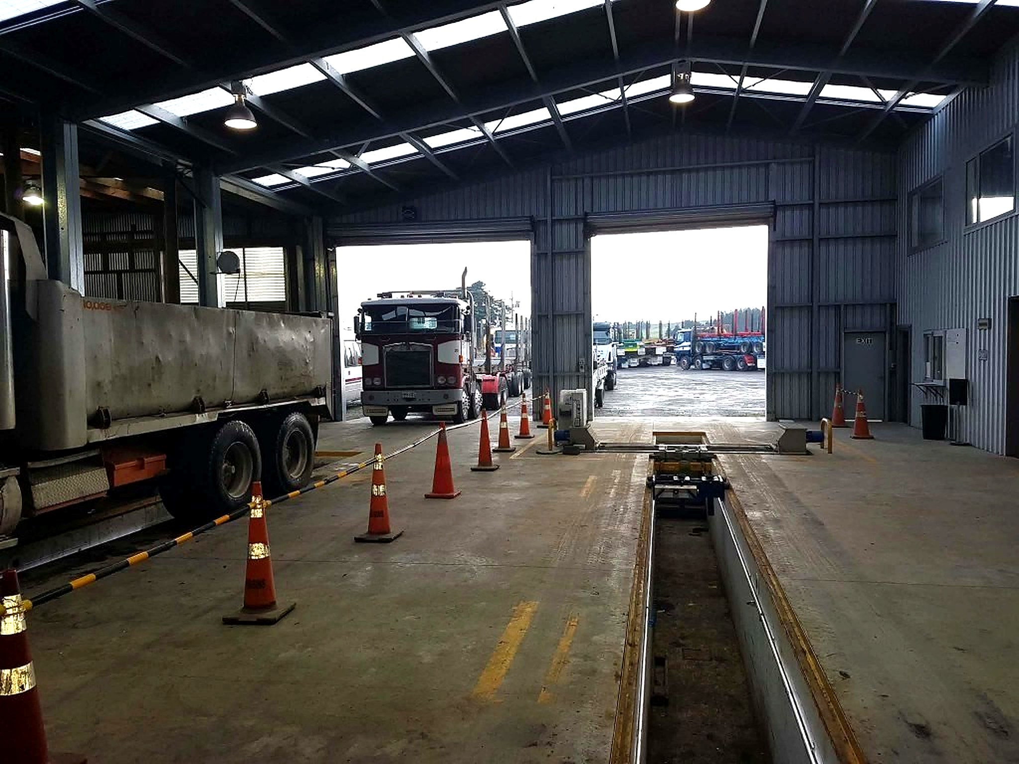 Looking out of the Holmes workshop bay at trucks waiting beyond the pit